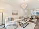 Sun-drenched living room with white sofa, decorative pillows, and modern lighting fixture at 3064 Selwyn Ave, Charlotte, NC 28209