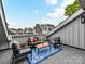 Relaxing rooftop deck features cozy seating, a stylish outdoor rug, and lovely views of surrounding townhomes at 3064 Selwyn Ave, Charlotte, NC 28209