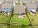 Aerial backyard view featuring a patio area with a fire pit, manicured lawn, and a fence-enclosed outdoor space at 3129 Burnello Ct, Iron Station, NC 28080