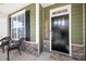Cozy front porch featuring a stylish black door, stacked stone accents, and comfortable seating for relaxing outdoors at 3129 Burnello Ct, Iron Station, NC 28080