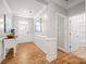 Inviting hallway with hardwood floors, white trim, and a view of the front door at 3129 Burnello Ct, Iron Station, NC 28080