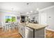 Open concept kitchen with island and granite counters, flowing into the dining and living areas at 3129 Burnello Ct, Iron Station, NC 28080