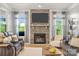 Cozy living room featuring a stone fireplace, leather sofas and light-filled windows at 3129 Burnello Ct, Iron Station, NC 28080