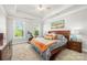 Spacious main bedroom with a tray ceiling, a large bed, and abundant natural light at 3129 Burnello Ct, Iron Station, NC 28080