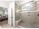 Tiled shower with a built-in bench, window, and decorative accent tiles at 3129 Burnello Ct, Iron Station, NC 28080