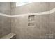 Close up of a tiled shower featuring a built-in bench, window, and storage niche at 3129 Burnello Ct, Iron Station, NC 28080