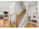 Carpeted staircase featuring a wooden banister and view into the living room with fireplace at 3129 Burnello Ct, Iron Station, NC 28080