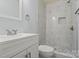 Updated bathroom with white marble style shower, shower niche, updated fixtures, and matching flooring at 313 Villa St, Kannapolis, NC 28083