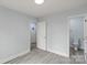 This light gray bedroom features wood-look flooring and a doorway leading to an adjoining bathroom at 313 Villa St, Kannapolis, NC 28083