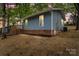 Charming blue home with a brick foundation, wood deck, and lush surrounding trees at 313 Villa St, Kannapolis, NC 28083