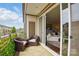 Inviting balcony with patio chairs, rug, and a view through sliding glass doors into the bright living room at 3216 Moss Ln, Charlotte, NC 28206
