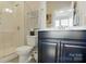 Bathroom featuring a glass enclosed shower, a vanity with dark cabinets and a framed mirror at 3216 Moss Ln, Charlotte, NC 28206