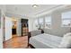 Bedroom with a dark wood sleigh bed, hardwood floors, tray ceiling, three windows and attached bathroom at 3216 Moss Ln, Charlotte, NC 28206