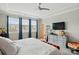 Bright bedroom featuring a tray ceiling, three windows with blue curtains, and a large dresser with television at 3216 Moss Ln, Charlotte, NC 28206