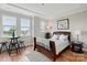 Bedroom features a dark wood sleigh bed, hardwood floors, tray ceiling, and three windows for plenty of natural light at 3216 Moss Ln, Charlotte, NC 28206