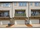 Exterior view of townhomes with garages and inviting balconies, creating a desirable residential setting at 3216 Moss Ln, Charlotte, NC 28206