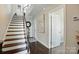Open hallway features a staircase with dark wood treads, hardwood floors, and white trim at 3216 Moss Ln, Charlotte, NC 28206
