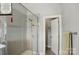 Bright shower with gray tiling, a glass enclosure, and silver fixtures, adjacent to the bathroom doorway at 3216 Moss Ln, Charlotte, NC 28206