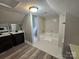 The bathroom features a dual sink vanity, white tiled shower over tub and a wood look floor at 3824 Freedom Dr, Charlotte, NC 28208