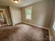 Cozy bedroom features wall-to-wall carpeting, neutral walls, and a large window at 3824 Freedom Dr, Charlotte, NC 28208
