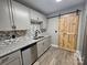 Updated kitchen with gray cabinets, granite countertops, stainless steel appliances, and a barn door at 3824 Freedom Dr, Charlotte, NC 28208