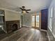Spacious living room featuring a brick fireplace, ceiling fan, and views of french doors at 3824 Freedom Dr, Charlotte, NC 28208