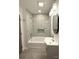 Bathroom boasts marble tiled walls, modern vanity, and shower-tub combination at 401 Baker St, Gastonia, NC 28052