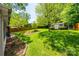 Picturesque backyard featuring a lush lawn, mature trees, garden beds, and a storage shed for outdoor tools at 4224 Firwood Ln, Charlotte, NC 28209