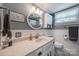 This bathroom is equipped with a round mirror, a toilet, and a sink at 4224 Firwood Ln, Charlotte, NC 28209