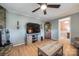 Living room with a stone fireplace, wood-look floors, and a modern entertainment center at 4224 Firwood Ln, Charlotte, NC 28209