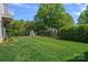 Expansive, manicured backyard with lush lawn, bordered by mature trees and landscaping, featuring a charming teepee play area at 503 Walnut St, Davidson, NC 28036