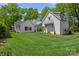 Lush green backyard featuring both the home and detached garage, with manicured lawn and elegant landscaping at 503 Walnut St, Davidson, NC 28036
