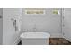 Bathroom with a freestanding tub and polished chrome fixtures under two windows at 503 Walnut St, Davidson, NC 28036