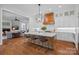 Open-concept kitchen boasts a center island, custom hood, stainless steel appliances, and hardwood flooring at 503 Walnut St, Davidson, NC 28036