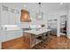 Bright kitchen features a large island, stainless steel appliances, custom cabinets and hardwood floors at 503 Walnut St, Davidson, NC 28036