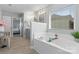 Bright bathroom featuring a soaking tub beneath a large window and view into the main bedroom area at 5035 Terrier Ln, Fort Mill, SC 29707