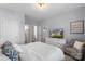 Comfortable bedroom includes a soft bed, dresser with a TV, and a sitting chair by the window at 5035 Terrier Ln, Fort Mill, SC 29707