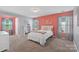bedroom featuring a large bed with white linens and a pink accent wall with an adjacent sitting area at 5035 Terrier Ln, Fort Mill, SC 29707