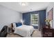 Bedroom featuring blue accent wall, neutral colored carpet, window with natural light and a dark wood dresser at 5035 Terrier Ln, Fort Mill, SC 29707