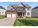 Charming two-story home featuring a stone facade, covered porch, and well-manicured lawn at 5035 Terrier Ln, Fort Mill, SC 29707
