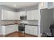 Bright kitchen with white cabinetry, stainless steel oven and microwave, and gray backsplash at 5035 Terrier Ln, Fort Mill, SC 29707