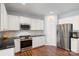 Modern kitchen featuring white cabinets, stainless steel appliances, and dark hardwood flooring at 5035 Terrier Ln, Fort Mill, SC 29707