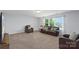 Spacious living room with plush carpeting, a comfortable leather sofa and chair set, and plenty of natural light at 5035 Terrier Ln, Fort Mill, SC 29707