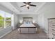 Bright main bedroom showcasing a comfortable bed, ceiling fan, and neutral tones for relaxation at 5035 Terrier Ln, Fort Mill, SC 29707