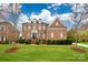 Stately brick home featuring a manicured lawn, mature trees, and classic architectural details at 548 Fairwoods Dr, Huntersville, NC 28078