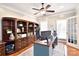 Well-lit home office with custom built-in shelving, desk, and french doors at 548 Fairwoods Dr, Huntersville, NC 28078