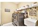 This laundry room features shelving, a utility sink, and a silver washing machine and dryer at 548 Fairwoods Dr, Huntersville, NC 28078