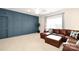 This living room features a brown leather sectional, a large window, and blue accent wall at 548 Fairwoods Dr, Huntersville, NC 28078