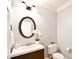 Powder room featuring dark wood vanity, updated fixture, and a round mirror at 548 Fairwoods Dr, Huntersville, NC 28078