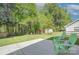 Beautiful backyard offers a well-manicured lawn, green Adirondack chairs, patio, and mature trees at 599 Annalinde Ln, Rock Hill, SC 29732